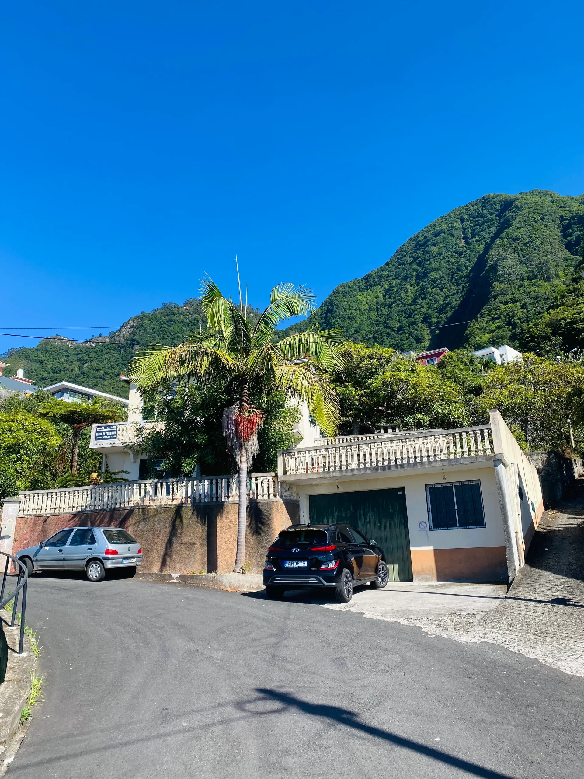 A detached home with carport on a hillside street in Madeira